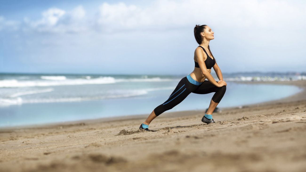 Attractive woman stretching on the beach